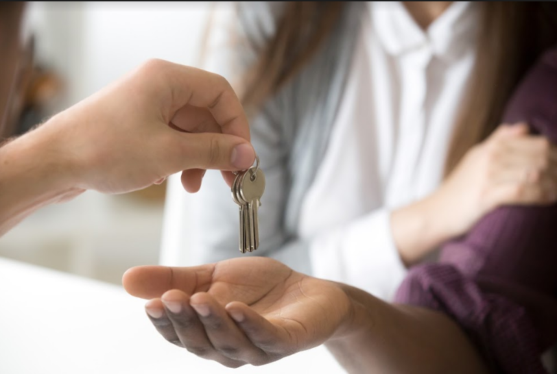 A seller giving house keys to a homebuyer